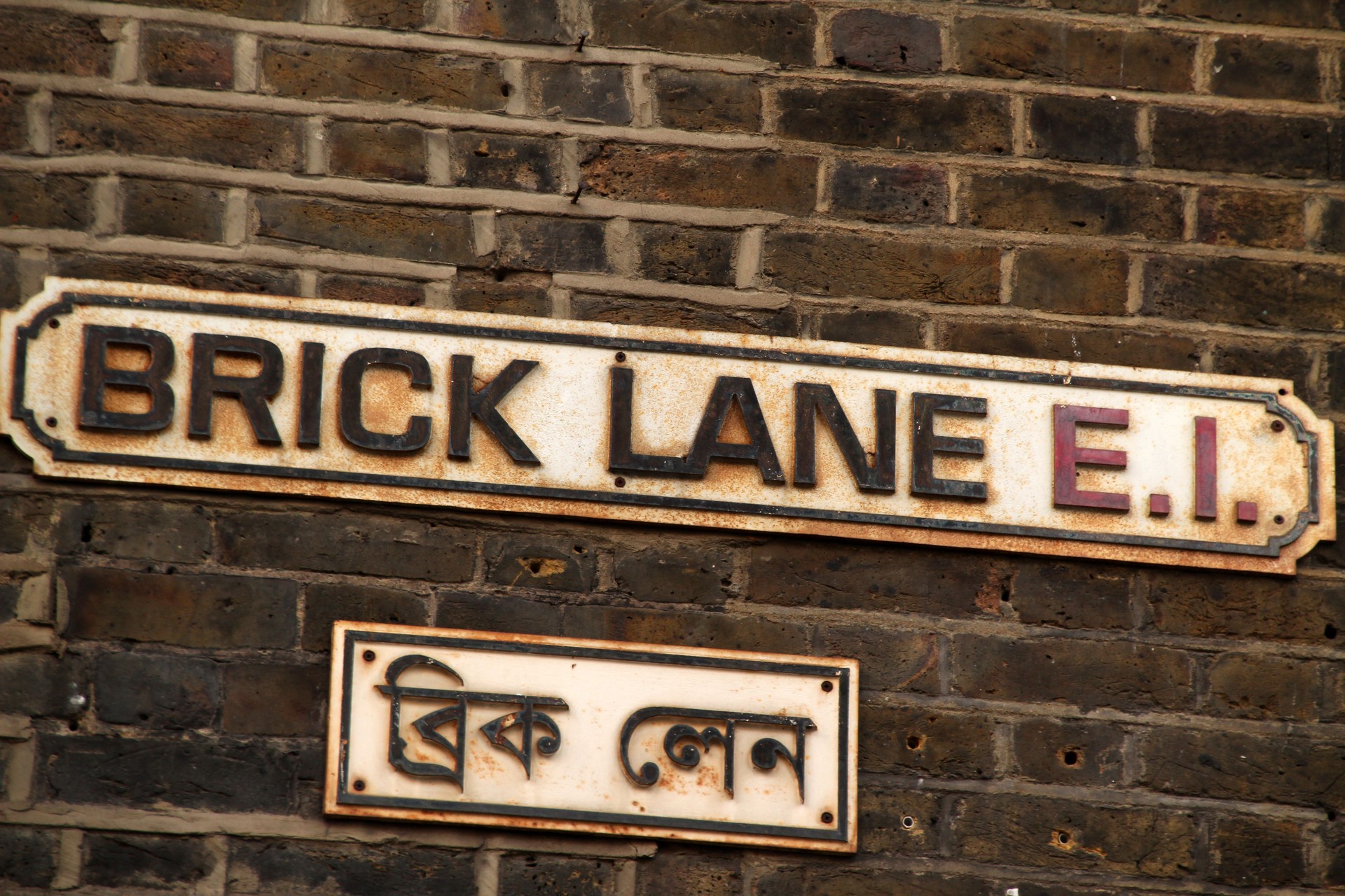 Vintage sign hanging on a brick building on a street in Shoreditch, London
